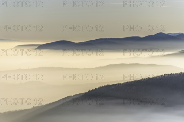 The mountains are shrouded in mist and the sky is a mixture of blue and white. The bleak atmosphere