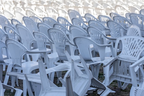 Seating for outdoor event, rows of chairs, overturned garden chairs made of plastic, plastic,