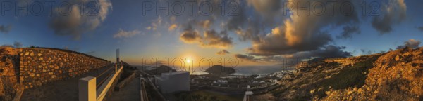 360° panoramic image of an enchanting sunset over the coastal landscape with the town of Arkasa,