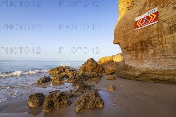 ROCKFALL UNSTABLE CLIFFS, KEEP A SAFE DISTANCE is written in English on a warning sign in Portugal