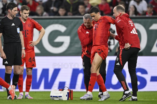 Jamal Musiala FC Bayern Munich FCB (42) injured Injury is led off the pitch by the coaches Josip