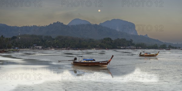Before sunrise, longtail boats lie at low tide in the harbour at Sivalai Beach, Koh Mook Island,