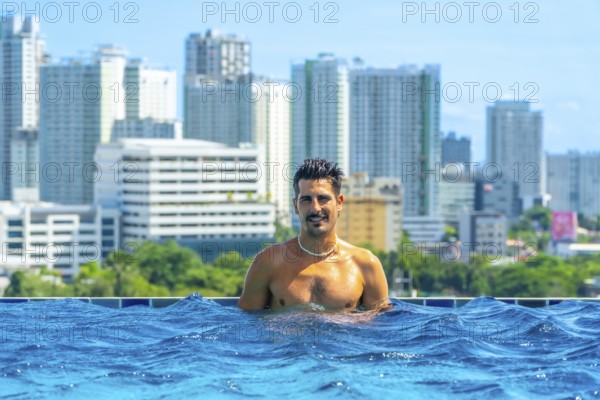 Tourist enjoying refreshing swim in rooftop infinity pool with breathtaking view of cebu city