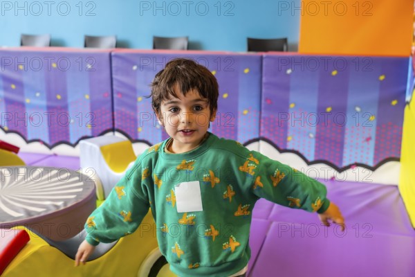 Preschooler enjoying playtime in a vibrant and stimulating indoor play area, promoting early
