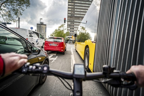 Cycling in the city, city centre road, no cycle path, bus stop, two-lane traffic in both