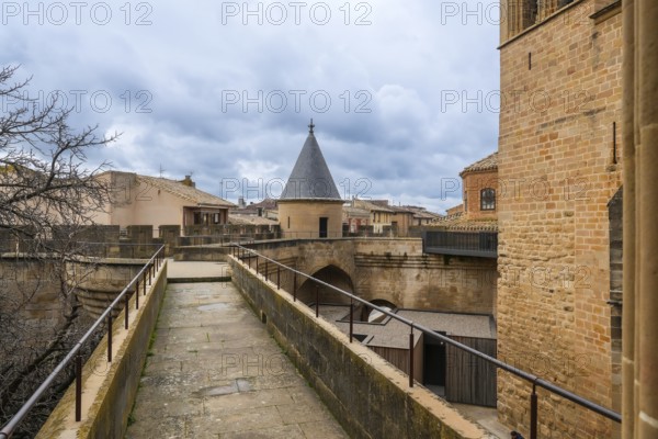 Stone walkway and watchtower rising above the rooftops of olite, offering breathtaking views of the