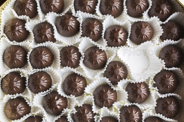Top view and close-up of opened chocolate box with one chocolate missing or eaten, Studio