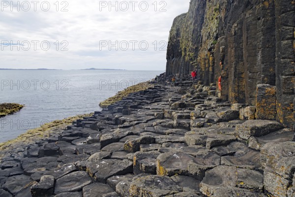 Majestic rock formation with basalt columns on a rugged coastline by the sea, Staffa, Hebrides,
