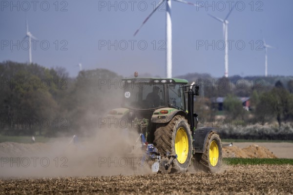 A tractor works a field, due to long dryness in spring, no rain for more than 4 weeks, the fields