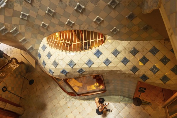 High angle view of a tourist capturing the colorful ceramic tiles and curved staircase design