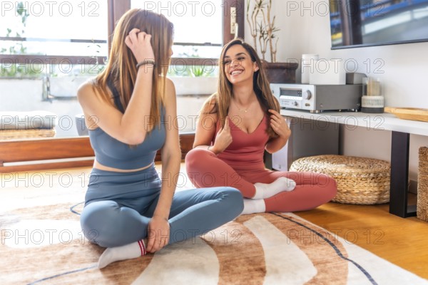 Two friends enjoying an online class, practicing yoga and meditation in a cozy living room setting,