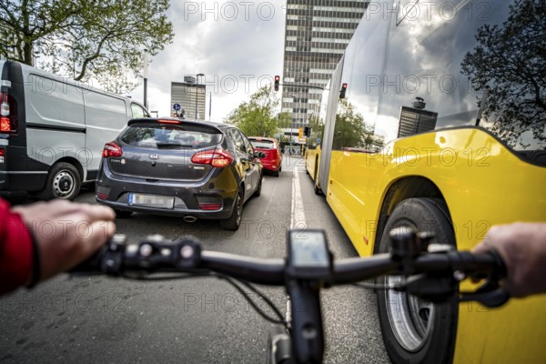 Cycling in the city, city centre road, no cycle path, bus stop, two-lane traffic in both