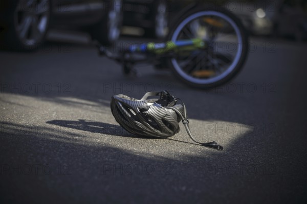 Symbol photo on the subject of bicycle accidents (posed scene) . A broken bicycle helmet lies next