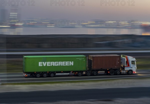 Lorry on the road from Euromax Terminal Rotterdam, ENECO wind farm on the dike around the port of
