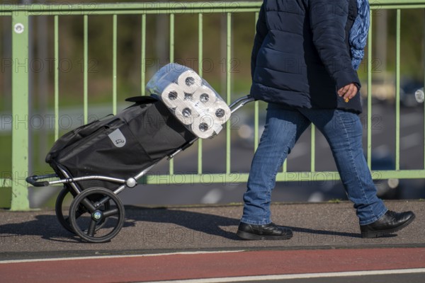 Effects of the coronavirus crisis, woman bought a large pack of toilet paper, Cologne, Germany,
