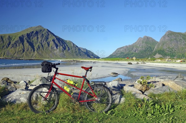 A bicycle on the beach with a view of the surrounding mountains and the sea, Flakstad, Lofoten,