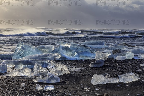 Ice floes on the beach, waves, sea, clouds, sunlight, winter, Diamond Beach, Breidamerkursandur,