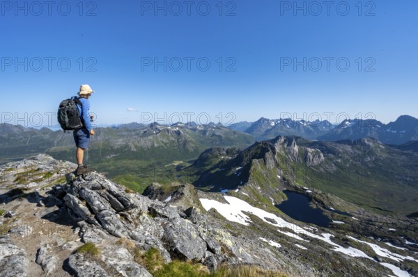 View of mountain landscape, mountain panorama, mountaineer at the summit of Rundfjellet, lake