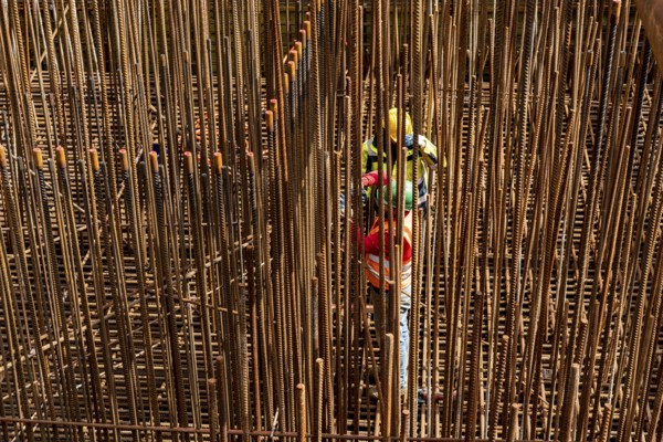 Construction site, reinforced concrete construction site, workers erect a mesh of reinforcing bars,