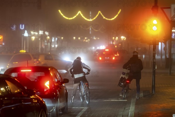 Cyclist, darkness, inner city traffic, Rüttenscheider Straße, bicycle lane, fog, autumn, winter,