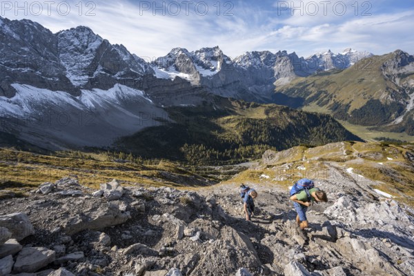 Two mountaineers on a hiking trail, mountain panorama with rocky steep peaks, view of summits