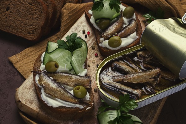 Sandwiches, black bread with sprats, cream cheese, cucumbers, on a cutting board, top view,