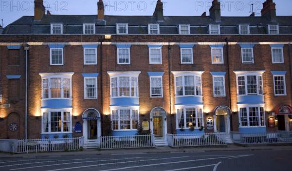 Row of guest houses and small hotels at night on the Esplanade, Weymouth, Dorset, England, United