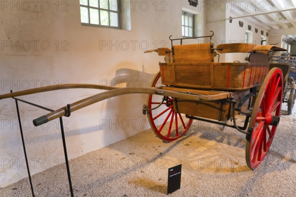 Historic wooden carriage with red wheels in a museum exhibition room, Tonneau carriage of the