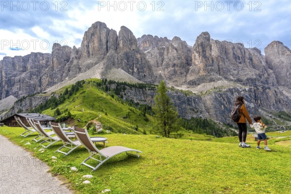 Tourists enjoying the breathtaking view of the dolomites mountain range at gardena pass during a