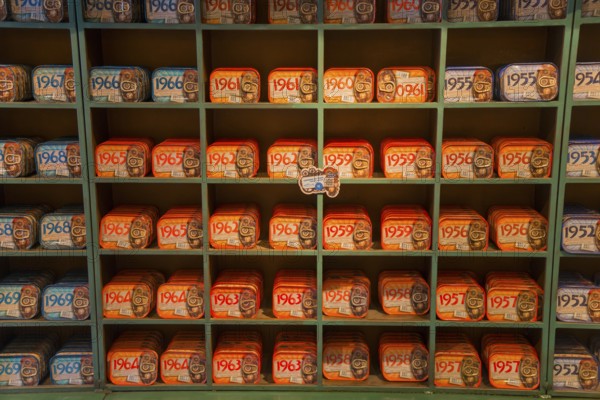 Shelves filled with a variety of colourful and artistically designed sardine tins that have a