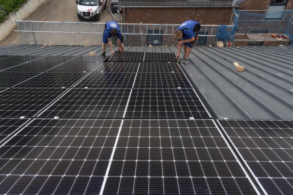 Installation of solar modules on the roof of a barn on a farm, over 240 photovoltaic modules are