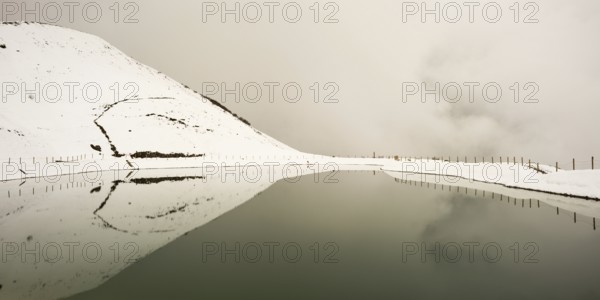Onset of winter in May, Riezler Alpsee, an artificial lake, snow pond, feeds the snow cannons that