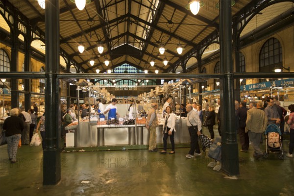 People shopping at fishmonger stalls inside historic covered market building, Jerez de la Frontera,