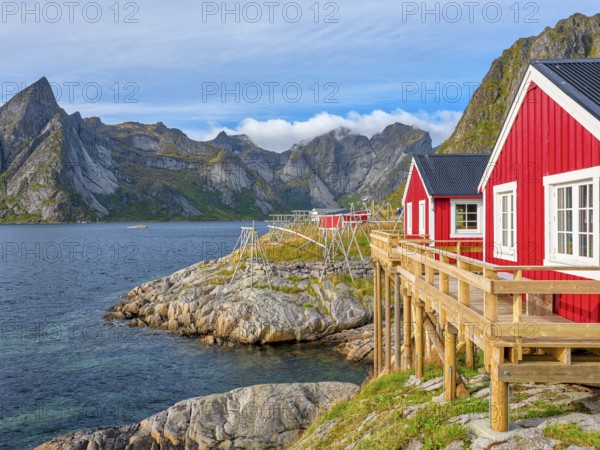Rorbuer in Hamnoy in front of the mountain Olstinden, blue sky, Moskenesoya, Lofoten, Norway,