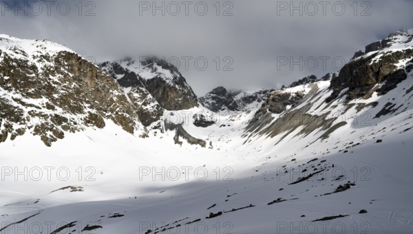 High mountain valley with mountain peak Piz Calderas in winter, view at the Chamanna Jenatsch in