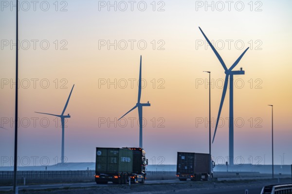 Lorry on the road from Euromax Terminal Rotterdam, ENECO wind farm on the dike around the port of
