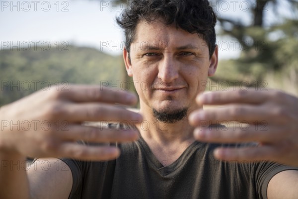 Close-up of a Caucasian adult man practicing the static posture of Tree Hugging, an essential