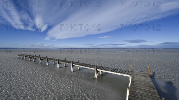 Frozen lake with ice and footbridge in winter, Lake Neusiedl, Podersdorf am See, Burgenland,