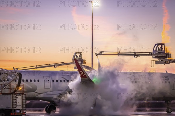 Frost at the airport, a Turkish Airlines aircraft is de-iced in front of sunrise. Airbus A321-231,