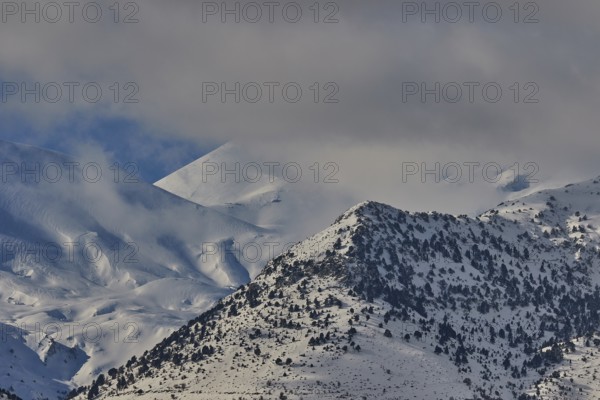 Snow-covered mountain range under a cloudy sky, Lefka Ori, White Mountains, mountain massif, west,