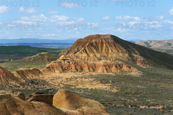 Rocky mountain landscape with clear blue skies and green valleys that create a sunny desert