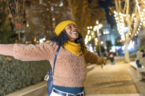 Young woman embracing the festive spirit of christmas lights while enjoying a winter evening in the