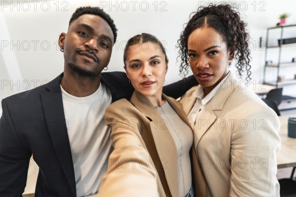 Three diverse business professionals are taking a selfie, showcasing their teamwork and positive