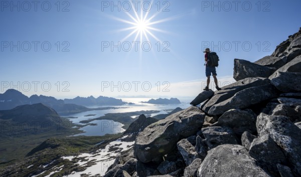 View of mountains and fjord landscape, mountaineer at the summit of Rundfjellet, Sun Star,