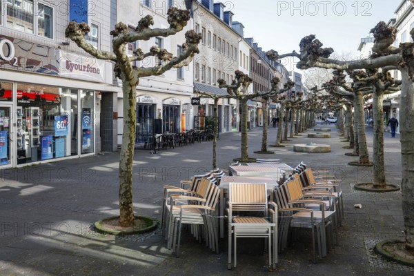 Deserted shopping street with closed shops due to corona pandemic contact ban, main street in the