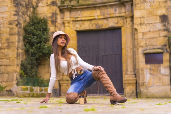 A young Latin woman with a white t-shirt, jeans and a hat enjoying the summer holidays, with a take