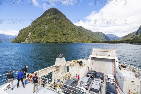 Passengers view the mountains and fjord landscape on the car ferry between Hornopirén and Caleta