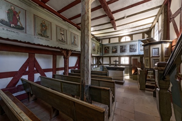 Historic half-timbered church, interior with wooden benches, altar and pulpit, church from