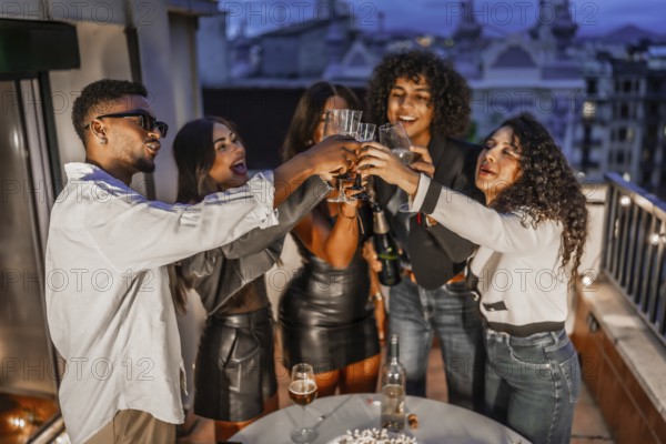 Top view of diverse and happy elegant multi-ethnic friends toasting with champagne during roof
