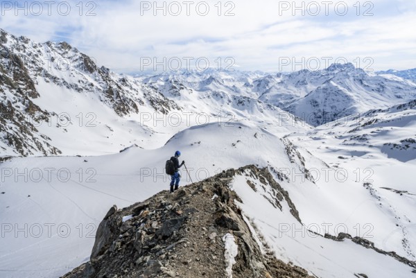 Mountain panorama with view of peaks of the Bernina group, mountaineer descending Piz Grialetsch in